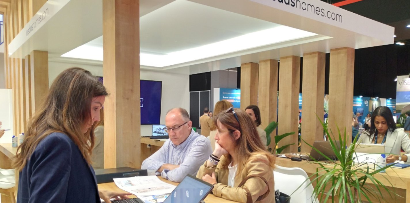 Una pareja recibe información de la oferta de AEDAS Homes en el SIMA 2023