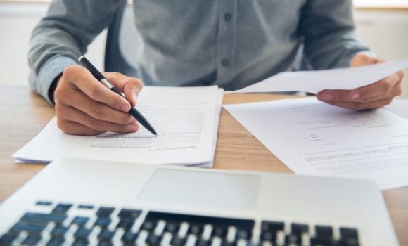 Una persona gestionando sus documentos para comprar una casa con AEDAS.